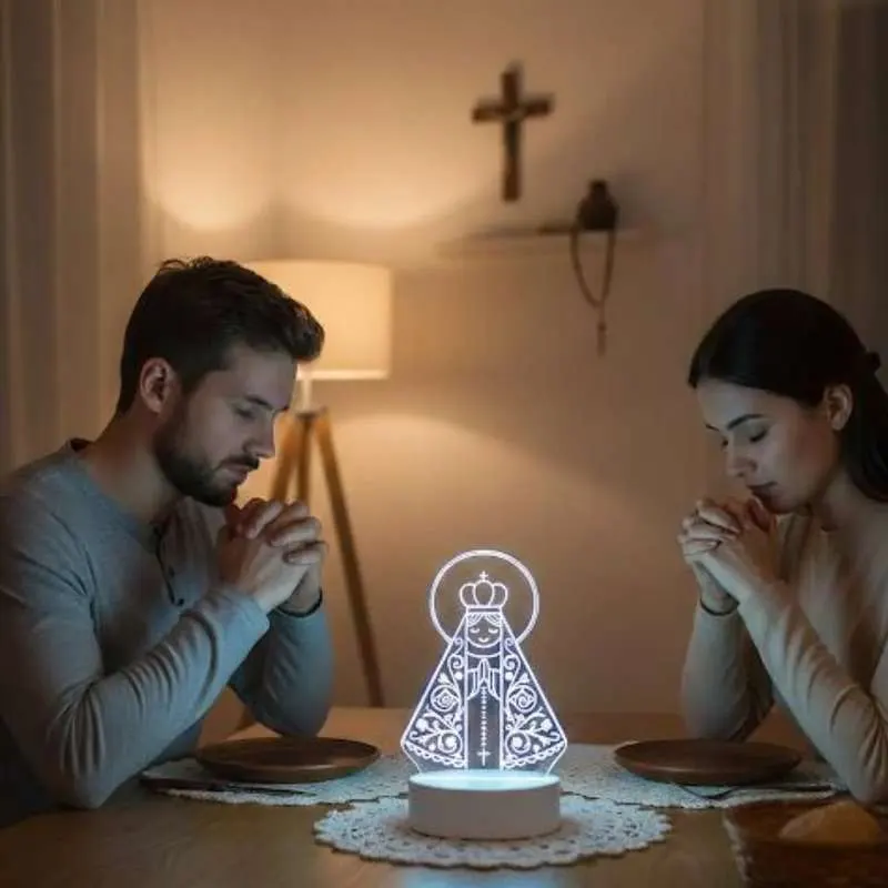 Casal orando em frente à luminária